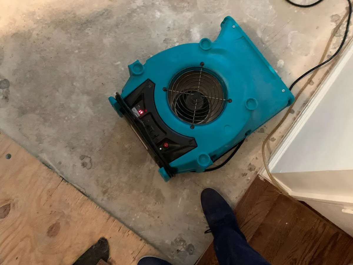 Air mover drying subfloor during Commercial Water Damage Restoration in Holdenville